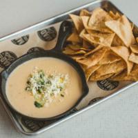 Street Corn Queso Plate · Spicy white queso topped with charred corn, onion, cilantro and feta cheese served with corn...