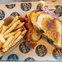 Caprese Grilled Cheese  · Melted fontina, cheddar and swiss cheese with sliced tomato and basil pesto on grilled sourd...