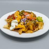 Chili Nachos · Chips with chili, cheeses, tomatoes, onion, jalapenos, and sour cream.