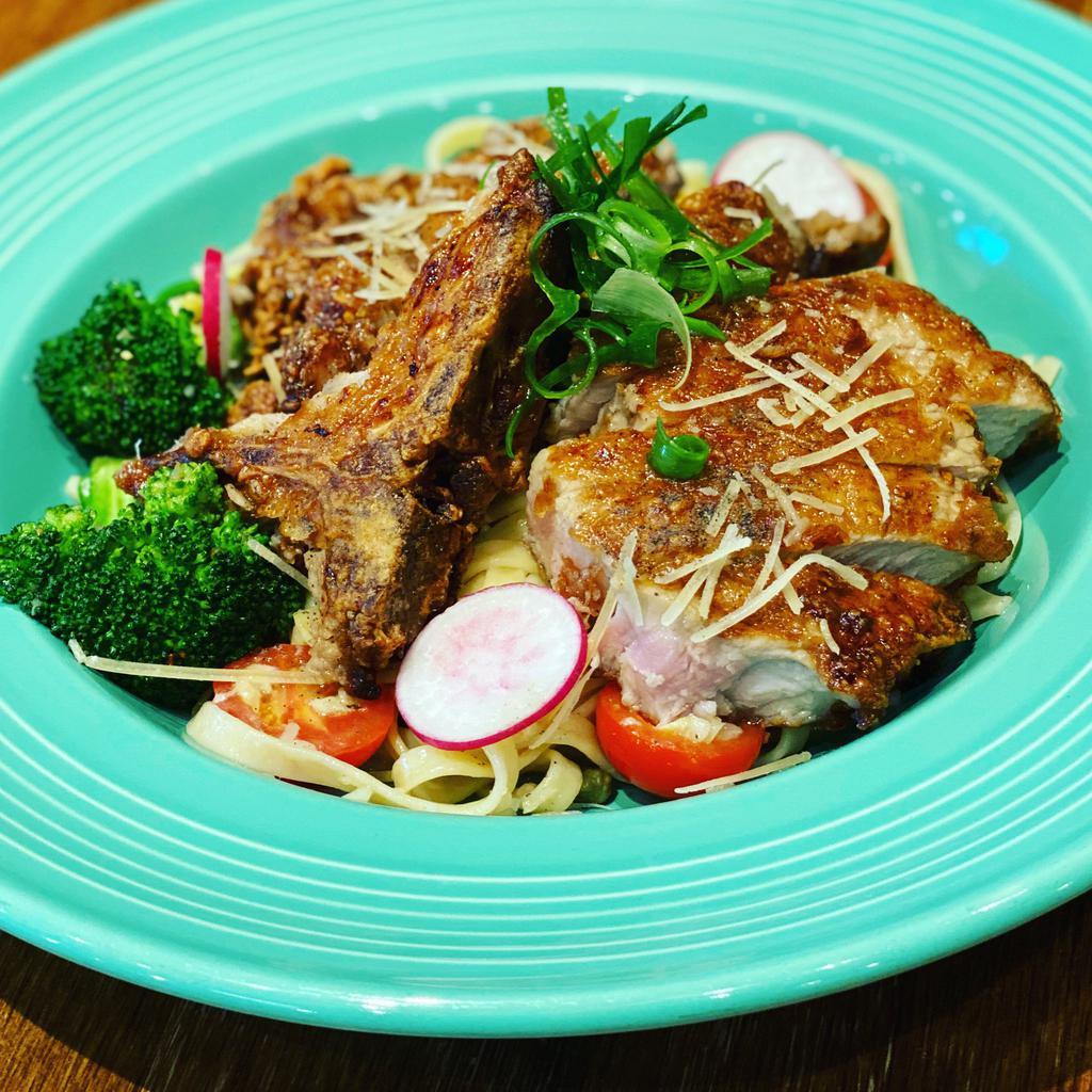 Grandmas Fried Pork Chop Pasta  · 8 oz. battered pork chop fried golden brown served on top a bed of fettuccini pasta tossed in a garlic lemon caper sauce topped with parmesan cheese served with sautéed broccoli and cherry tomatoes.