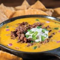 Jack’s Skillet Queso · House Made Queso topped with seasoned ground beef, sour cream and green onions. Served with ...