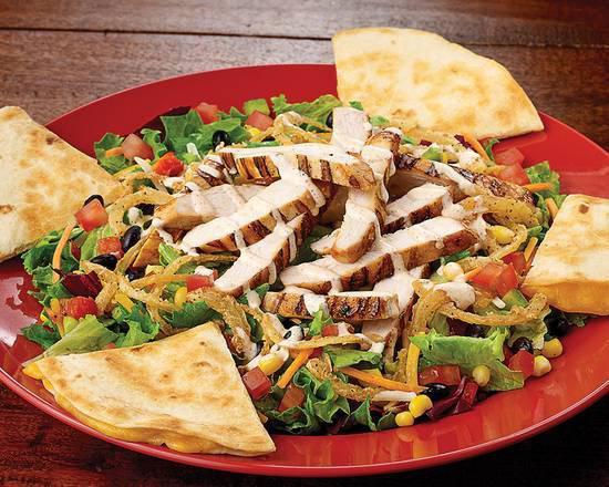 Southwestern Quesadilla Chicken Salad · Grilled chicken, black bean corn relish, tomatoes, cilantro, and quesadilla wedges drizzled with chipotle ranch. Served with House-made Ranch
