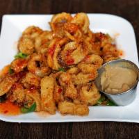 Sweet and Spicy Calamari · Tender calamari, topped with a sweet and spicy sauce and peanut ginger dipping sauce. Spicy.
