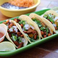 Tacos de Al Pastor · Marinated Al Pastor Pork. Four tacos served with fresh homemade corn tortillas, topped with ...