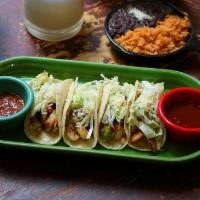 Tacos de Camarón · Shrimp tacos. Four tacos served with fresh corn homemade tortillas, topped with guacamole an...