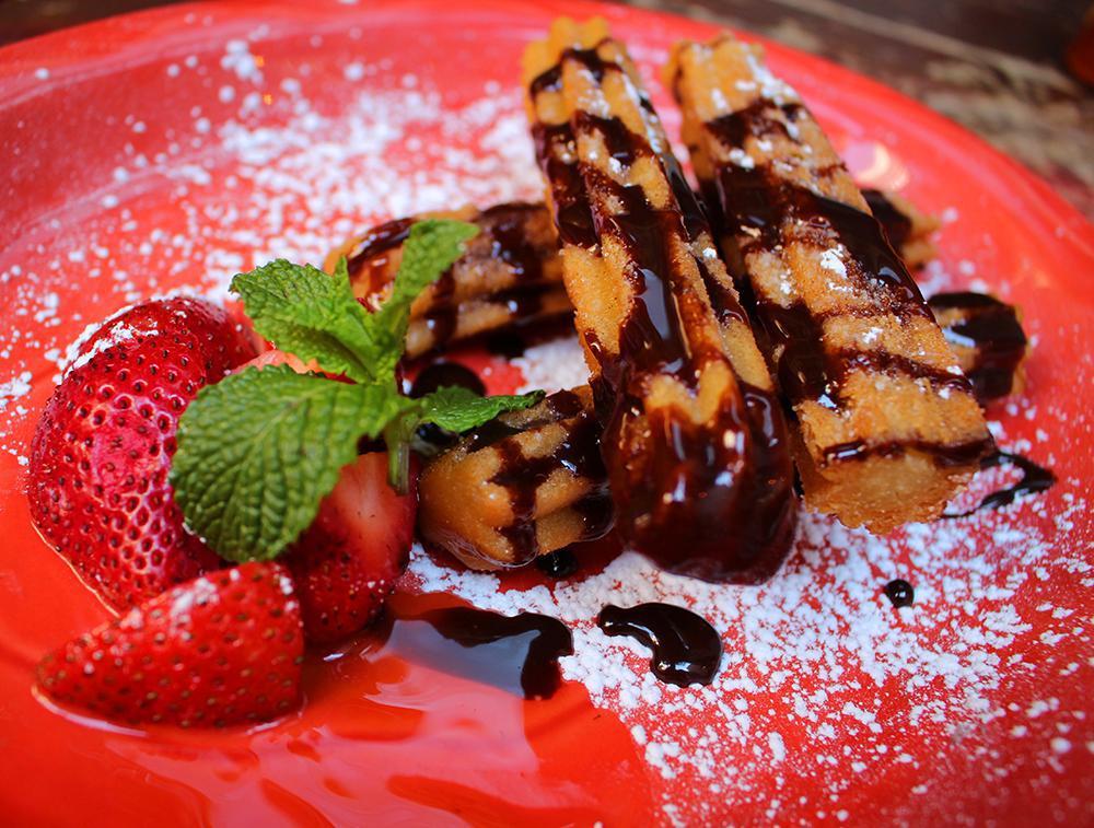 Churros · Mexican fried pastry tossed in cinnamon-sugar and served with chocolate sauce.