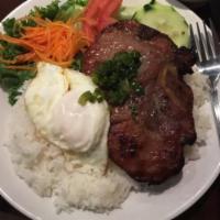 Com Suon Nuong · Steamed rice with charcoal grilled pork chop. Served with cucumber, lettuce, tomato, pickled...