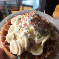 Rainbow Madness Waffle · Fruity pebbles cooked into Belgian waffle with whipped cream and bananas.