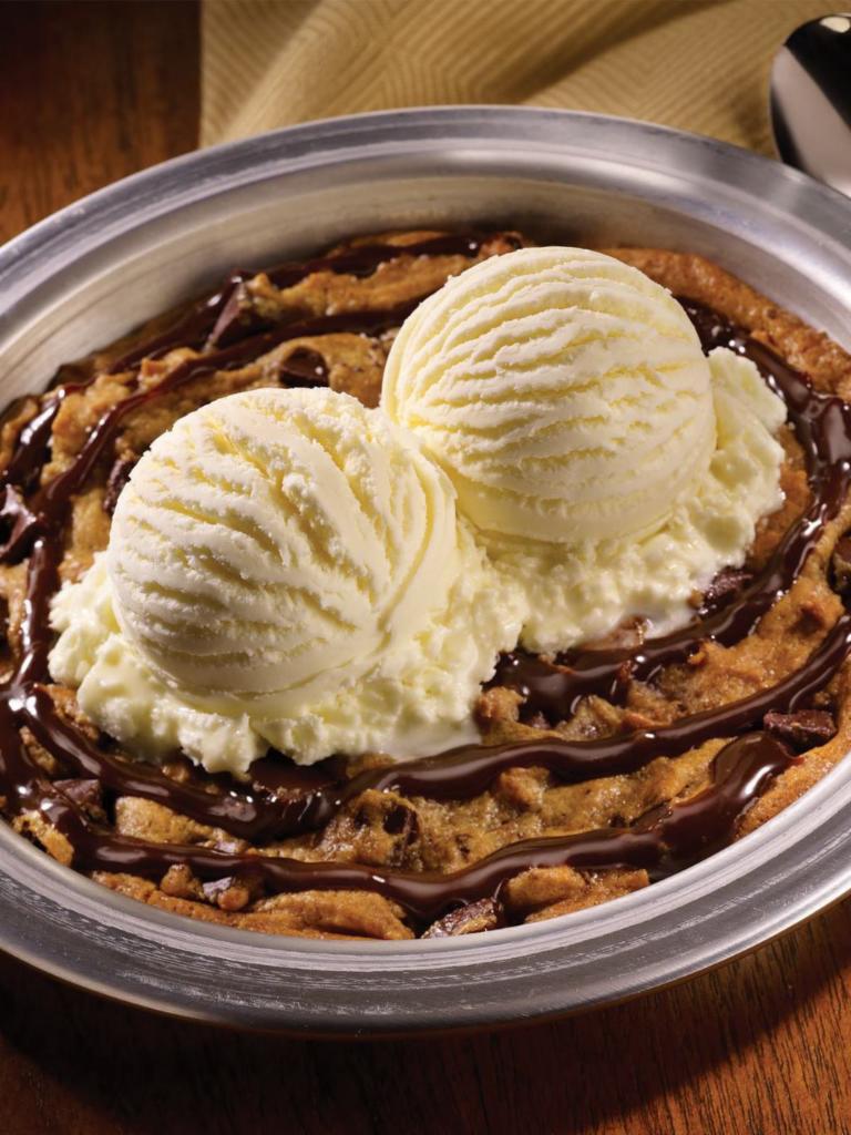 Cookie Blitz · Fresh-baked chocolate chip cookie, drizzled with chocolate syrup and topped with vanilla ice cream, salted caramel sauce, whipped cream and a cherry
