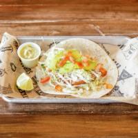 Tacos Fish · Topped with avocado, queso dip, lettuce, and tomato on a flour tortilla.