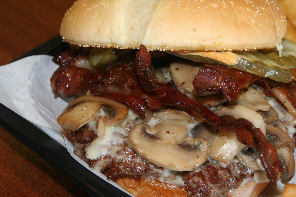 Mushroom Swiss Burger* · Handmade 6oz beef patty, swizz cheese, grilled mushrooms, grilled onions, garlic aioli mayo.