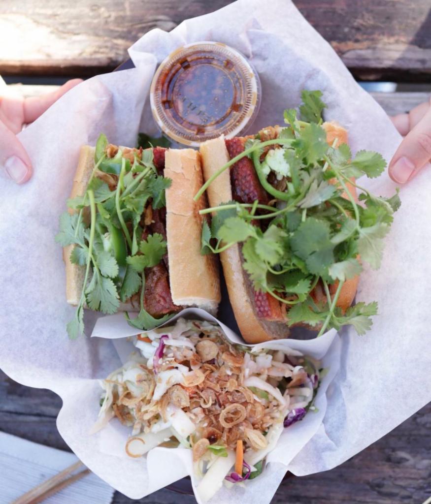 Vegan Roasted Pork Belly Sandwich · Vegan! Vietnamese baguette, vegan roasted pork belly (bean curd, coconut milk, tapioca starch, baguette), cucumber, pickled carrots & daikon, jalapeños, and cilantro. Cashew sauce on the side. Served with our vegan Vietnamese coleslaw. 
(COLESLAW CONTAINS CASHEW)