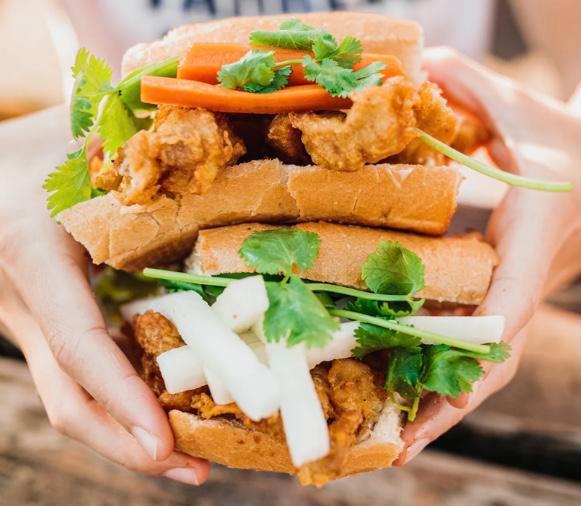 Chicken Katsu Sandwich · Vietnamese baguette, fried chicken, mayo, cucumber, pickled carrots & daikon, jalapeños, and cilantro. House garlic sauce on the side. Served with your choice of shrimp crackers or vegan Vietnamese coleslaw.
(COLESLAW CONTAINS CASHEW)