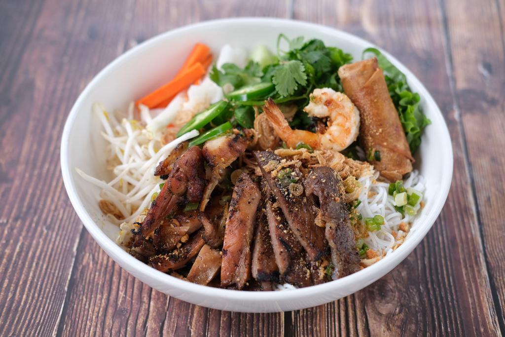Combo Vermicelli · Grilled lemongrass chicken, grilled pork, grilled prawns, vermicelli rice noodles, lettuce, fresh herbs, cucumber, beansprouts, pickled carrot and daikon, jalapenos, and topped with crushed cashews and crispy shallots. Served with fish sauce and a mung bean and taro egg roll.
