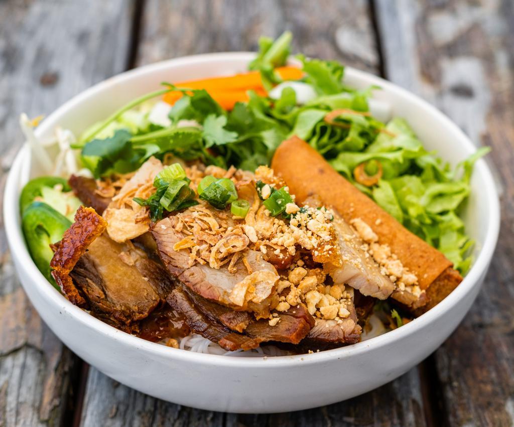 Pork Belly Vermicelli · Roasted pork belly, vermicelli rice noodles, lettuce, fresh herbs, cucumber, beansprouts, pickled carrot and daikon, jalapenos, and topped with crushed cashews and crispy shallots. Served with fish sauce and a mung bean and taro egg roll.

