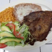 Milanesa de Res · Breaded beef steak served with rice, beans, salad and tortillas.