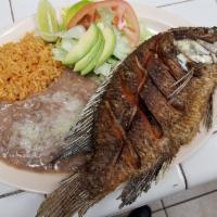Mojarra/whole fried fish · Fried fish served with rice, beans, salad and tortillas.