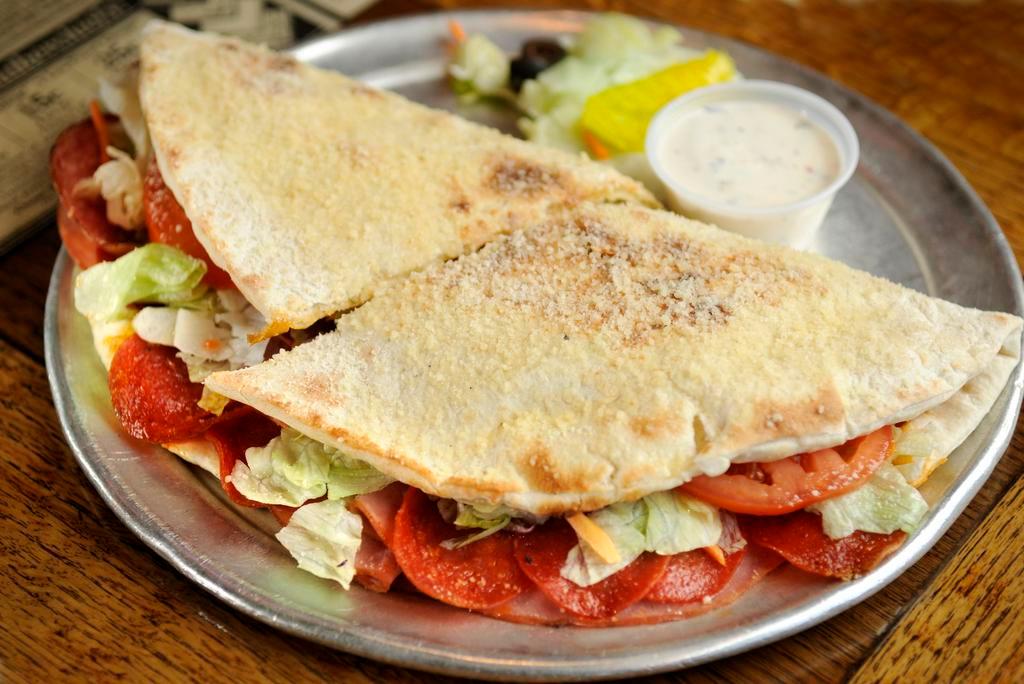 Chicago Torpedo · Ham, pepperoni, salami, Swiss cheese, crisp lettuce, sliced tomatoes and our creamy Italian dressing on the side. Served on pizza crust and topped with butter and parmesan.