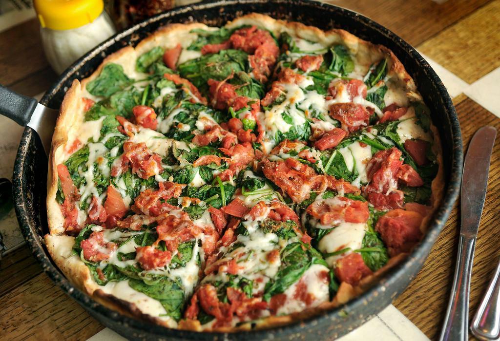 Spinach · Deep dish. Another Chicago favorite! A special mixture of fresh spinach, fresh chopped garlic, diced tomatoes and mozzarella cheese blended with herbs and spices with our rich pizza sauce and a light flaky deep pan crust.
