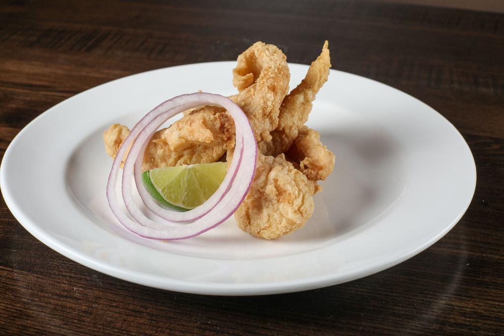 Chicarrones de Pescado · Crispy mojo marinated fish bites served with tartar sauce.