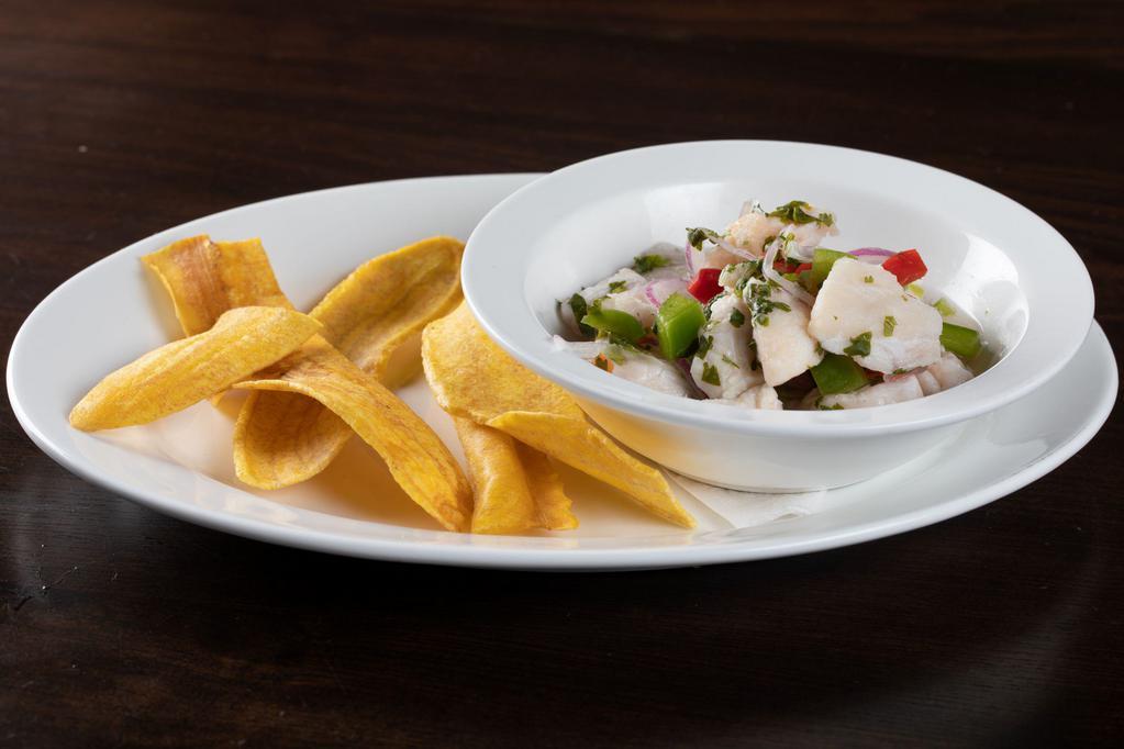Ceviche de Pescado Tradicional · Traditional fish ceviche marinated fish in lime juice, red onions, and cilantro served with crispy plantain chips.