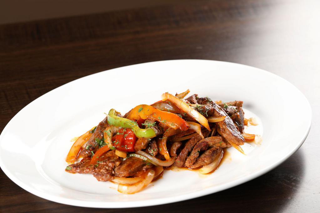 Bistec Salteado · Thinly sliced pieces of marinated steak, cooked with sauteed onions, green and red pepper.