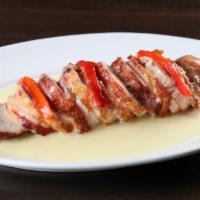 Pollo Rumbero · Chicken breast wrapped with bacon, stuffed with ham and Swiss cheese, and topped with a crea...