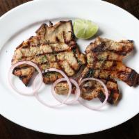 Chuleta a la Parrilla · A pair of pork chops slowly grilled with a splash of fresh lime.