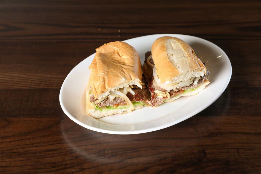Pan con Bistec Sandwich · Thin top sirloin steak, perfectly seasoned and grilled with sauteed onions, garnished with lettuce, tomatoes, and potato sticks on hot-pressed Cuban bread.