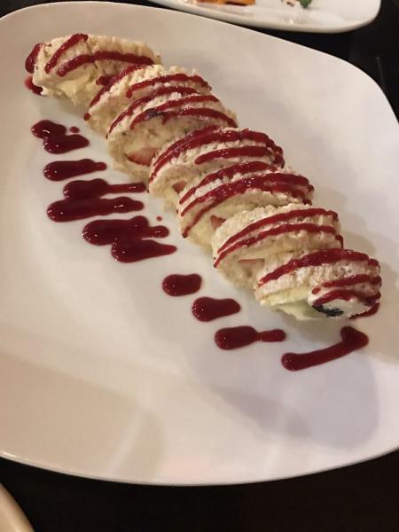 Wedashii's Crispii · Fresh fruit rolled in crispy rice and marshmallow cream roll with pastry cream and raspberry sauce.