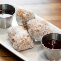 3.6.9. Donuts · Powdered sugar donuts with raspberry sauce and chocolate sauce.