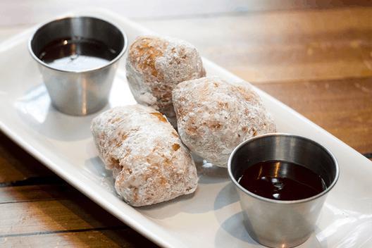 3.6.9. Donuts · Powdered sugar donuts with raspberry sauce and chocolate sauce.