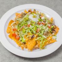 Nachos Texanos  · Corn tortilla chips topped with choice of meat, refried beans, melted cheese, lettuce, tomat...