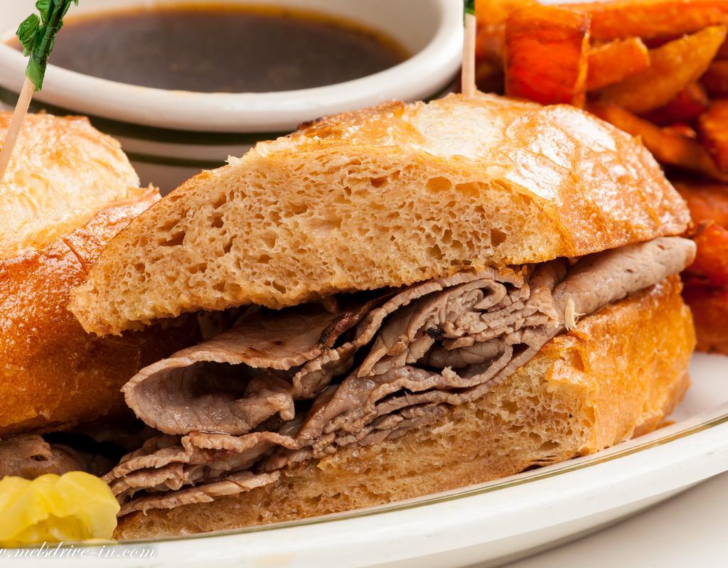 The French Dip Sandwich · Lean slices of roast beef on a French baguette. Served with au jus and American fries. 