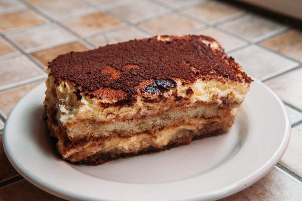 Italian Pie Tiramisu · Clouds of Light Mascarpone Cream on Pillows of Coffee, Rum-Soaked Lady Fingers and Finished with Powdered Sugar.  