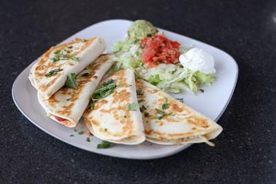 Quesadilla · Seasoned chicken, cheese, green chiles, onions and mild salsa.  Served with sour cream, pico de gallo and guacamole.