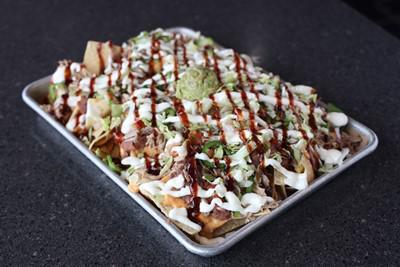 Tex Mex Nachos · Traditional nachos topped with seasoned ground beef, refried beans, chile con queso, jalapenos, lettuce, pico de gallo, guacamole and sour cream.