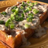 Sausage Waffle with Gravy · Waffle with sausage cooked inside and then topped with sausage gravy and green onions.
