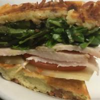 Turkey BLT Waffle Sandwich · Bacon waffle sandwich with oven-roasted turkey, Swiss cheese, pesto aioli, mixed greens, and...
