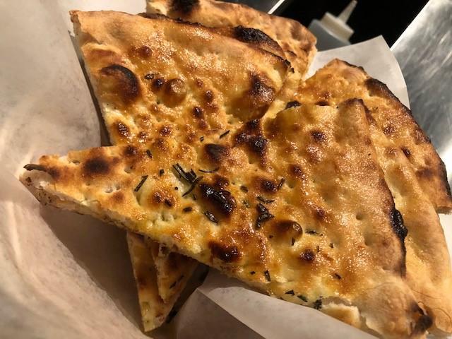 Il Cestino · Basket of focaccia with herbs.