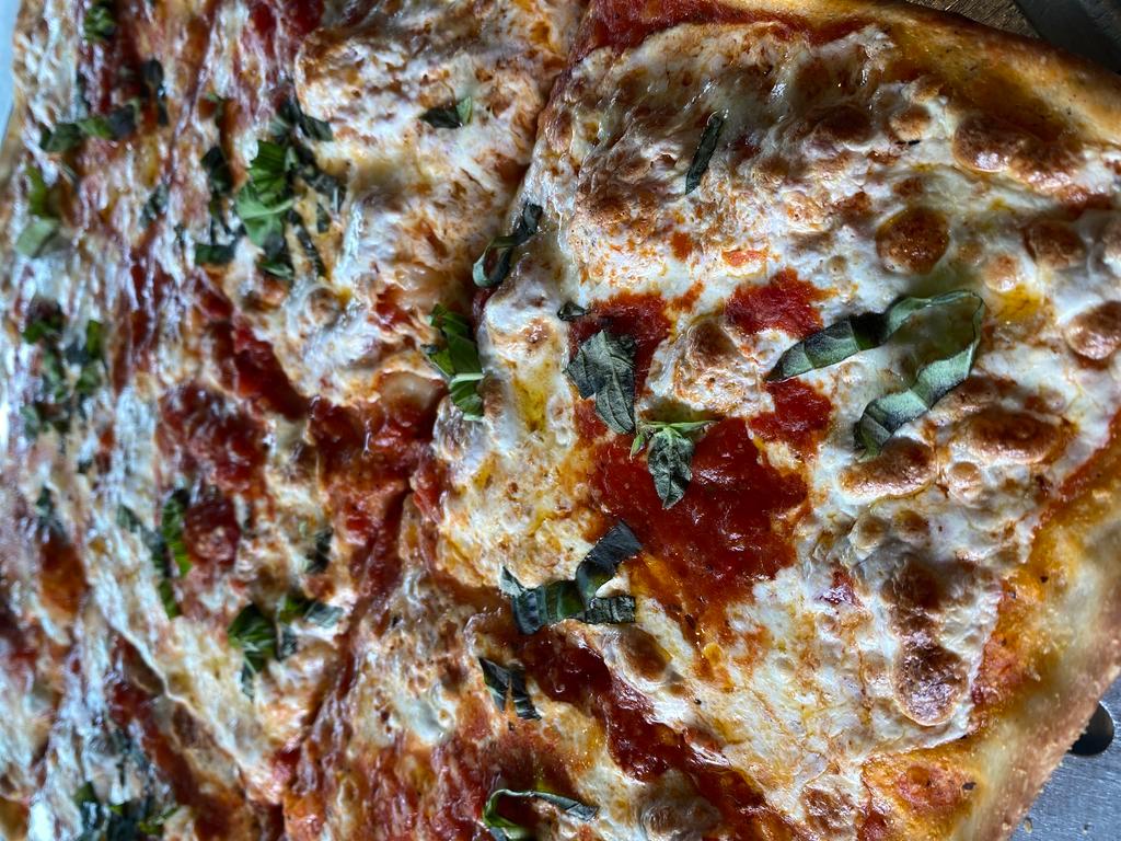 Grandma Sicilian Pizza · Remember the smell of grandma's homemade sauce simmering on the stove when you walked into her kitchen?  That's the same delicious smell and taste you'll get when you bite into our traditional grandma Sicilian pizza topped with chunky tomato sauce with basil, garlic and Parmigiano cheese.                  
​