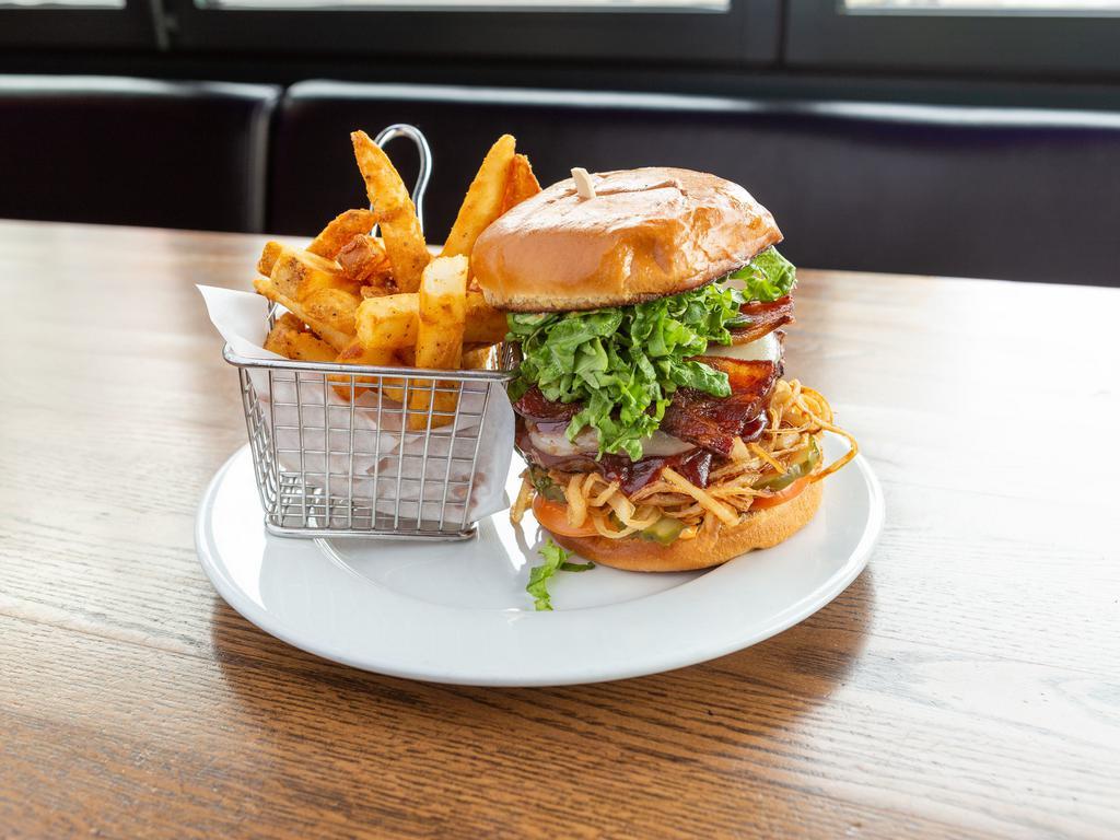 BBQ Bacon Burger · Our public house burger with a stack of bacon and a pool of BBQ sauce with lettuce, tomato, onion straws and pickles on a brioche bun.