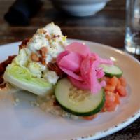 Wedge Salad · Iceberg wedge, tomatoes, cucumbers, pickled red onions, bacon, and blue cheese crumbles serv...