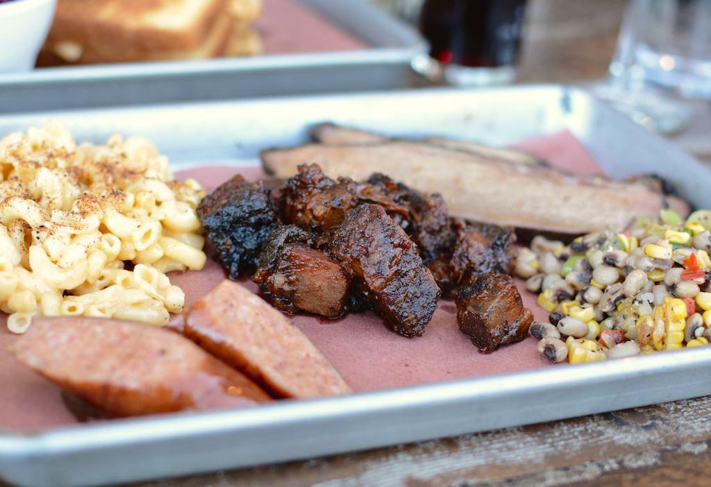 3 Meat Sampler Plate · Try a sample of our signature smoked meats: sliced brisket (4 oz), burnt ends (6 oz.) and smoked sausage. Served with two sides and choice of bread.