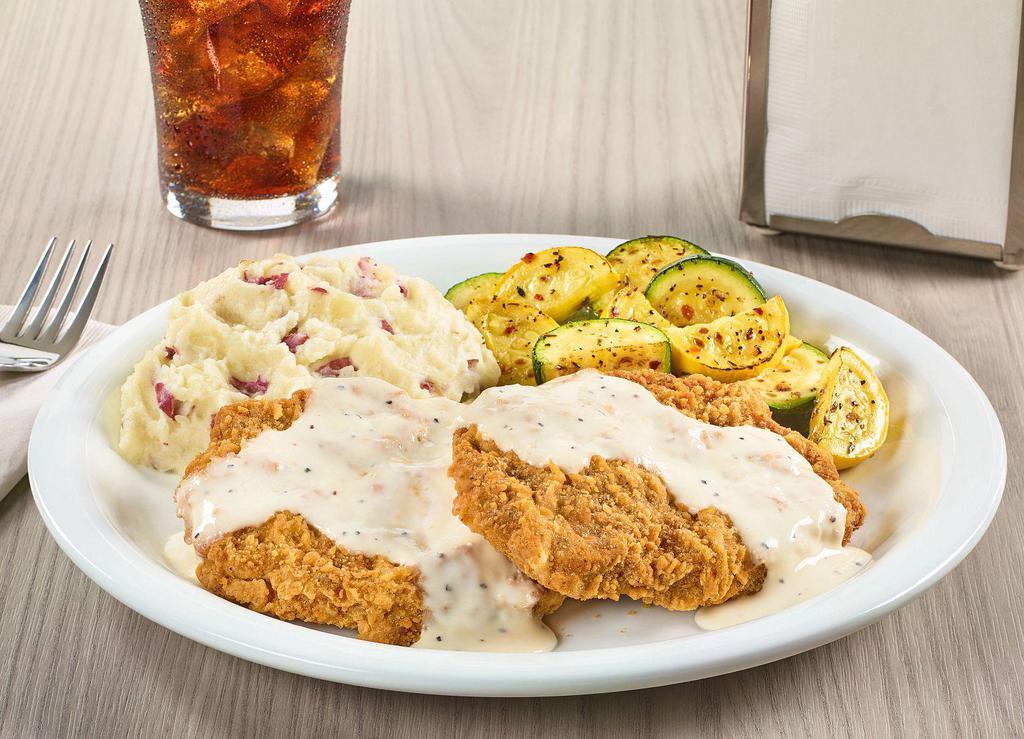 Country-Fried Steak · Two chopped beef steaks smothered in country gravy. Served with two sides and dinner bread.