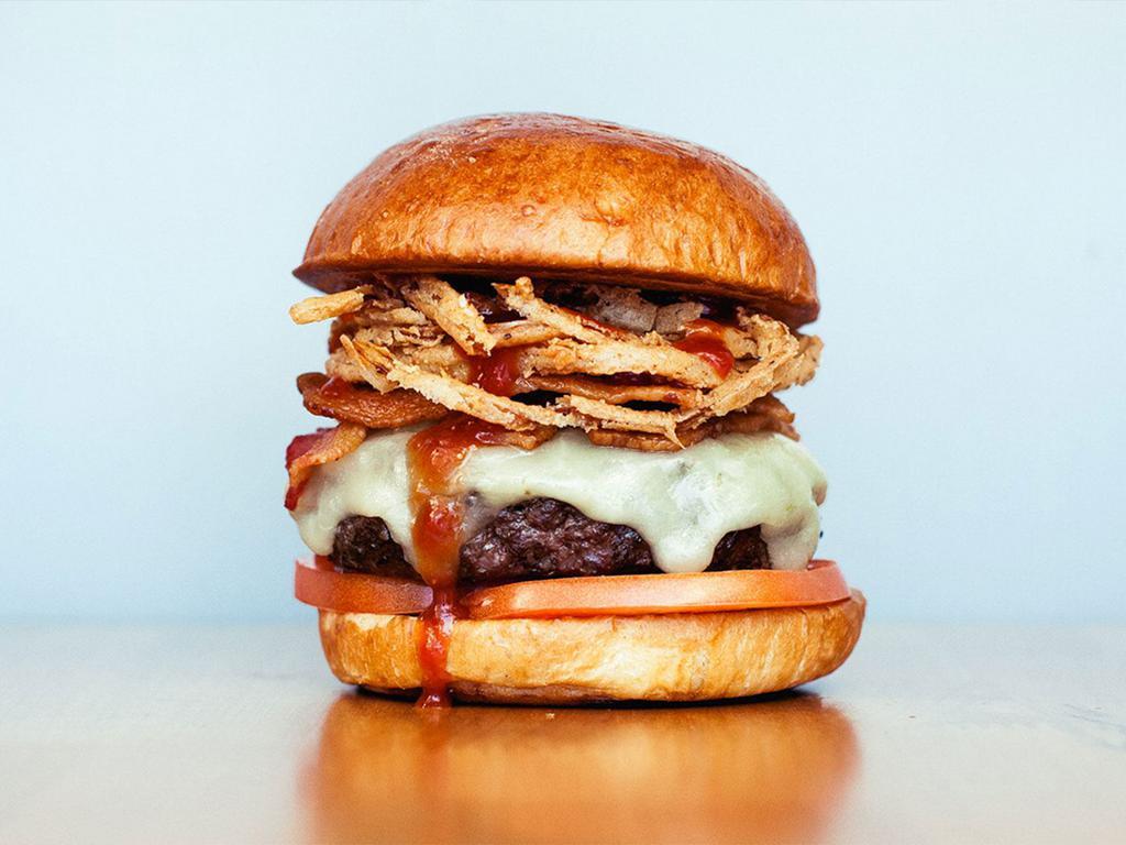 Bacon BBQ Burger · All natural beef, Tillamook cheddar, applewood smoked bacon, tomatoes, fried onion strings and hickory BBQ on a brioche bun.