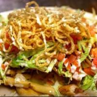 Trash Can Nacho · Fried corn tortilla chips, topped with french fries, chicken fingers, chopped bacon, onion s...