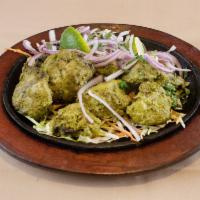Hariyali Chicken Kebab · Chicken marinated with fresh green herbs, served with grilled onion and salad.