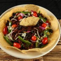 TACO SALAD · Nacho chips, salad greens, cheese, black olive, red onion, green peppers, tomato, spicy grou...