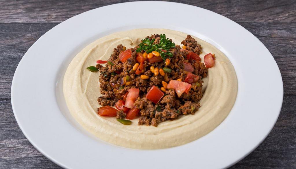 Hummus with Kafta Beef · ground beef mixed with minced onions, diced tomatoes, jalapeno, parsley, Mediterranean seasoning and pomegranate molasses, choice of hummus, toasted pine nuts and pita.